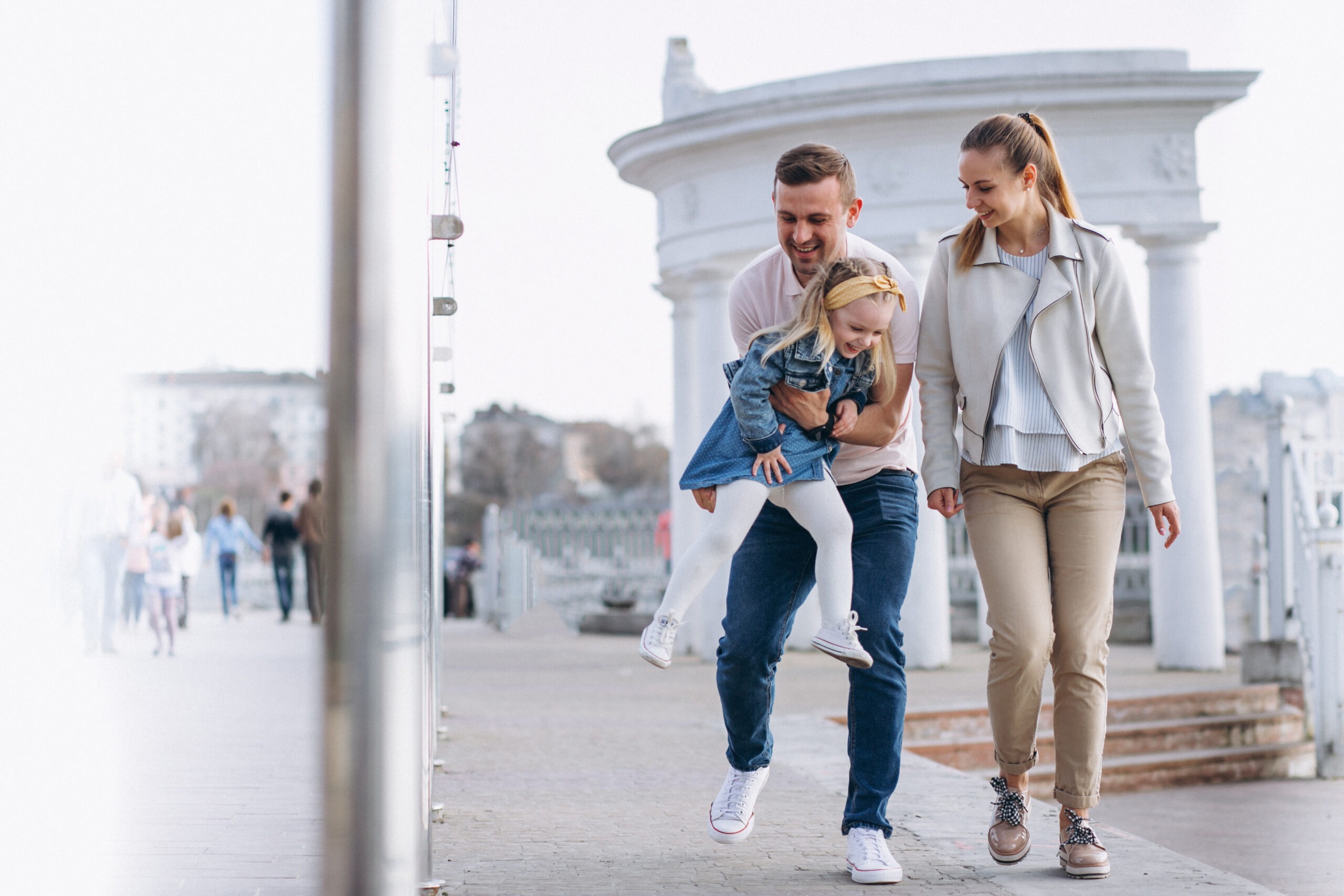 famiglia cin bambini Papà che tiene in braccio la figlia e la mamma di fianco sorride